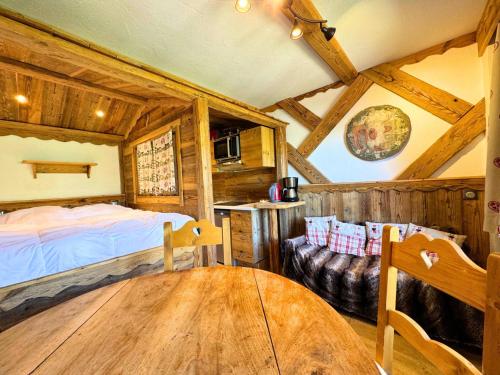 a bedroom with a bed and a table in a room at Résidence Necou - Studio déco style chalet en bord de pistes MAE-5954 in Les Menuires