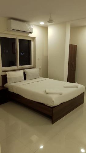 a large bed in a room with a window at Hotel EPH Malkajgiri in Hyderabad