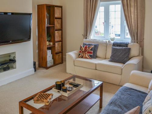 a living room with a couch and a coffee table at Crescent By The Sea in Newbiggin-by-the-Sea