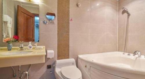 a bathroom with a toilet and a sink and a tub at Huangshan Yupinglou Hotel in Huangshan