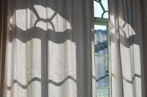 a window with curtains with a view of a mountain at Gasthof Hirschen in Eglisau