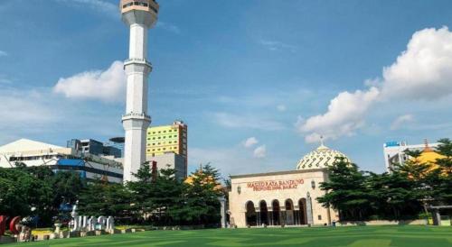 a building with a tower in the middle of a field at Raffleshom Hotel in Bandung