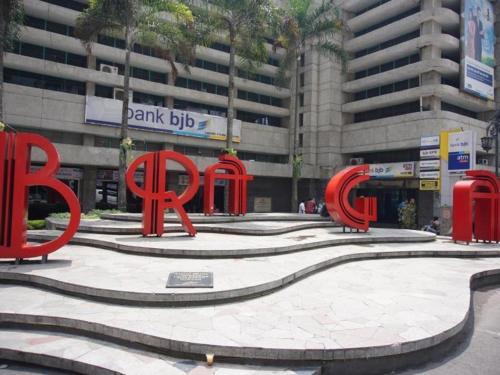 a large red sign in front of a building at Raffleshom Hotel in Bandung