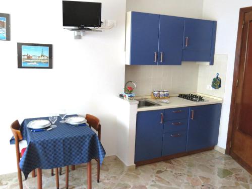 パレルモにあるAppartamento Bluの小さなキッチン(青いキャビネット、テーブル付)