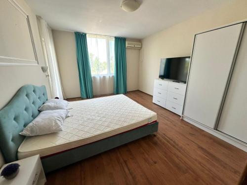 a bedroom with a bed and a flat screen tv at PSB Apartments in Midia Resort Aheloy in Aheloy