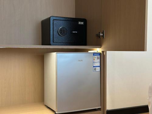 a small refrigerator with a television on a shelf at The MAJULAN Hotel in Kota Kinabalu