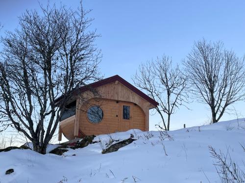 a small building with a clock on it in the snow at Gîtes BEL'M in La Bresse