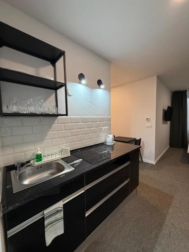 a kitchen with a sink and a mirror at Gremium Apartments in Bratislava