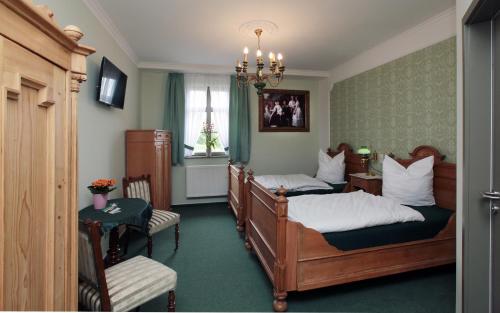 1 dormitorio con 2 camas y lámpara de araña en Hofgärtnerei en Altemburgo