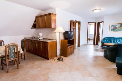 a kitchen and living room with a couch and a table at Friskó Panzió in Zalakaros