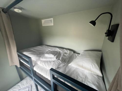 a small bed in a small room with a lamp at Gausta Sportell in Gaustablikk