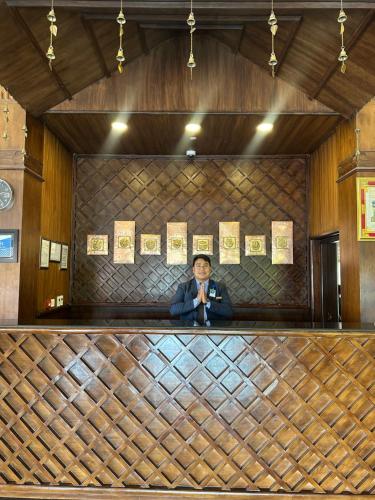 a man is standing behind a bar in a restaurant at Chandragiri Hills Resort Kathmandu-Luxury in the Clouds in Thānkot
