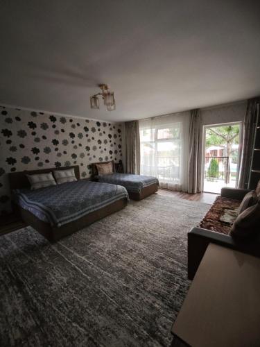 a large bedroom with two beds and a couch at Гостевой дом Лабиринт in Cholpon-Ata