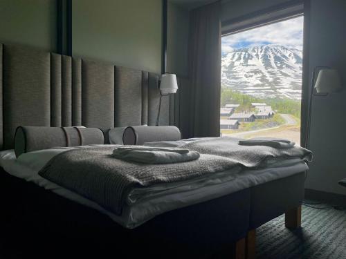 a bedroom with a bed with a view of a snow covered mountain at Gausta Sportell in Gaustablikk