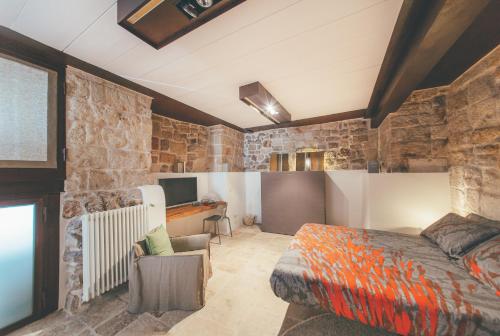 een slaapkamer met een bed, een bureau en een televisie bij La pergola in Polignano a Mare