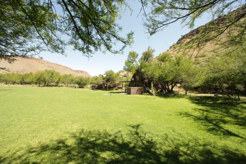 a large field of grass with mountains in the background at Ko Ka Tsara Bush Camp in Beaufort West