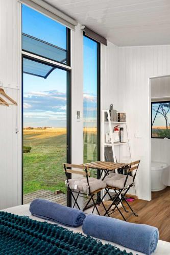 a room with a table and chairs and a large window at Avondale Heights by Tiny Away in Banyena