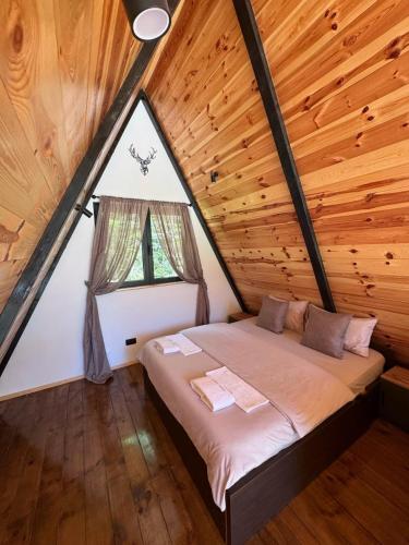 łóżko w pokoju z dużym oknem w obiekcie Alpine Lodge w mieście Žabljak
