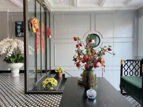 a living room with a vase with flowers on a table at Malisa Hotel in Như Thức