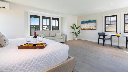 a white bedroom with a bed with a bottle of wine at MAUNA KEA BEACH ESCAPE Luxurious home in private community with Heated Private Pool and Spa Detached Ohana Suite in Waimea