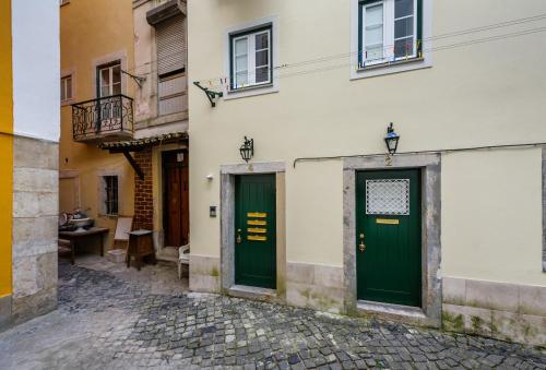 zwei grüne Türen an der Seite eines Gebäudes in der Unterkunft Galé Primeiro in Lissabon