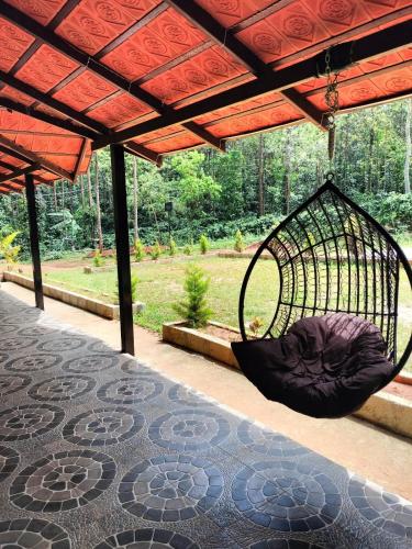 a hammock hanging from a pergola on a patio at Rainbow Villa in Chikmagalūr
