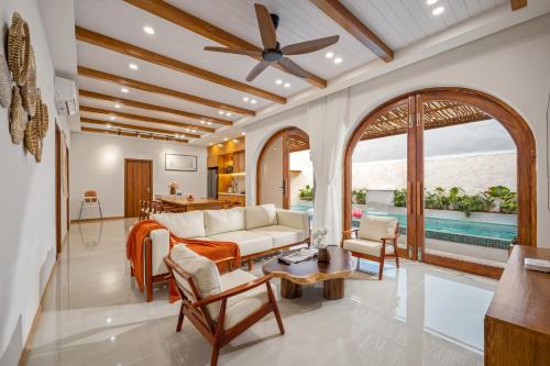 a living room with a couch and a ceiling fan at Tropical Villa - Near My Khe Beach & City Center by The Key in Da Nang