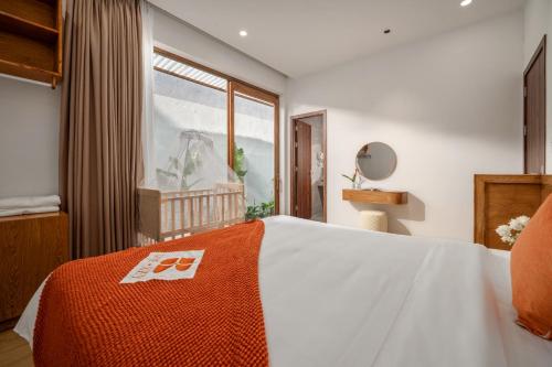 a bedroom with a bed with an orange blanket on it at Tropical Villa - Near My Khe Beach & City Center by The Key in Da Nang