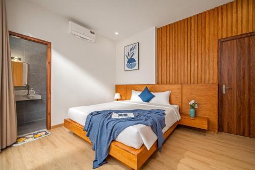 a bedroom with a bed with a blue blanket on it at Tropical Villa - Near My Khe Beach & City Center by The Key in Da Nang