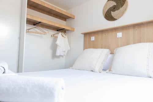 a bedroom with a white bed with white pillows at HolaCamp Sant Salvador in Comarruga