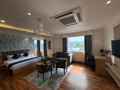 a hotel room with a bed and a table and a couch at Sinclairs Udaipur in Udaipur