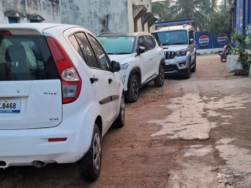 a row of parked cars parked on a dirt road at Lily Homestay in New Hampi