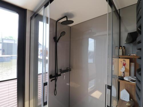 una ducha en un baño con pared de cristal en Houseboat with sauna & fantastic view Offingawier, en Offingawier