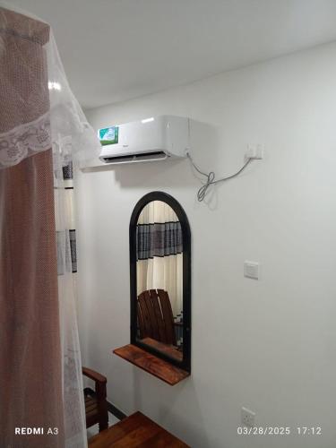 a room with a mirror and a tv on a wall at Solace Transit Villa in Katunayake