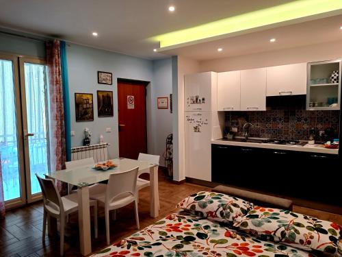 a kitchen and dining room with a table and a bed at Casa Azzurra in Giardini Naxos