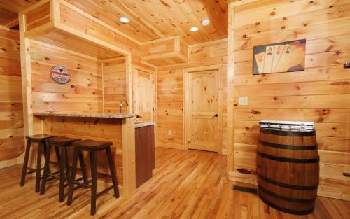 Cabaña de madera con cocina con barra y taburetes en Carsons Place, en Gatlinburg