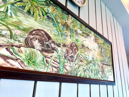 a painting of three squirrels on a wall at Sinurambi Cottage Rental in Penampang