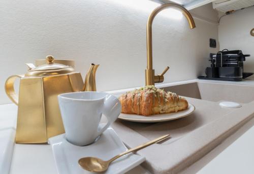 a kitchen counter with a plate of food and a cup at TEATRUM LOFT Teatro Galli -Jacuzzi in camera in Rimini