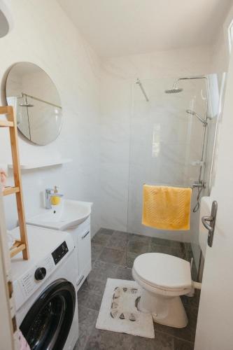 a bathroom with a toilet and a shower and a sink at Urban Nest in Ljubuški