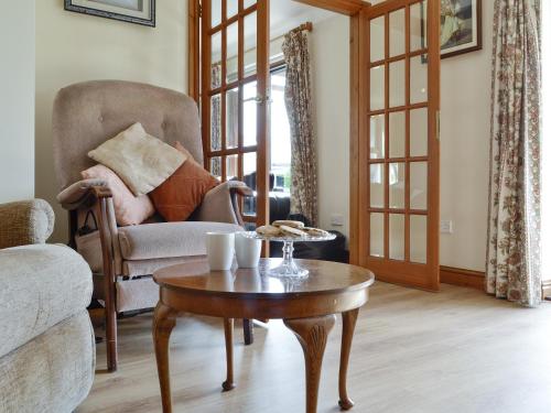 a living room with a chair and a coffee table at Three Views Bungalow in Talgarth