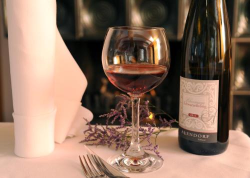 a glass of wine next to a bottle of wine at Naturhotel Lindenhof in Rechenberg-Bienenmühle