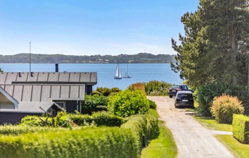 een huis en auto's geparkeerd op een weg naast het water bij Holiday Home Teglbakken Xii in Egernsund