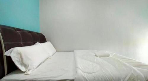 a bed with white sheets and pillows in a room at OYO 89859 PP Traveller's Hotel in Pasir Puteh