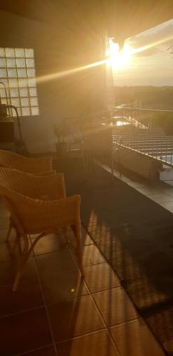 a sun setting on a building with a bench at Ferienwohnung Weitblick in Wadgassen