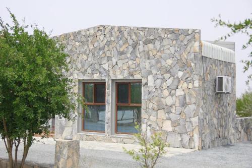 a stone building with a window in front of it at Jebel Shams Resort منتجع جبل شمس in Dār Sawdāʼ