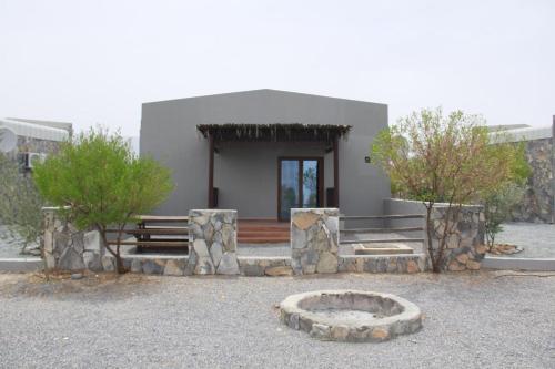 a building with a bench and a bowl in front of it at Jebel Shams Resort منتجع جبل شمس in Dār Sawdāʼ