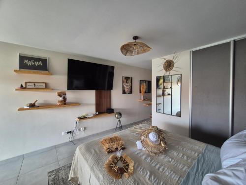 a living room with a bed and a flat screen tv at Vai'ei Nui Home in Papeete