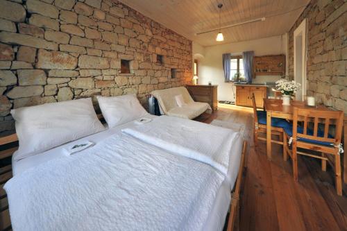 1 dormitorio con cama y pared de piedra en Galerie Kuks, en Kuks