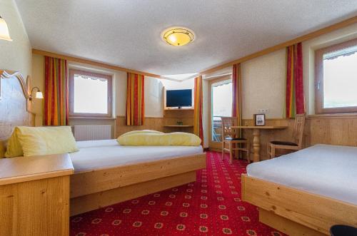 een hotelkamer met 2 bedden en een tafel bij Alpengasthof Enzianhof in Zell am Ziller