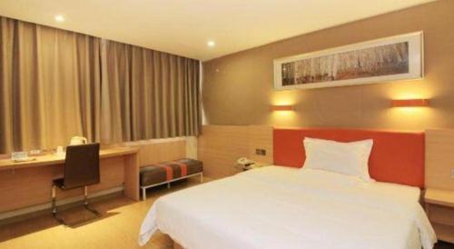 a hotel room with a bed and a desk at 7 Days Premium Zhuhai Gongbei Light Railway Branch in Zhuhai